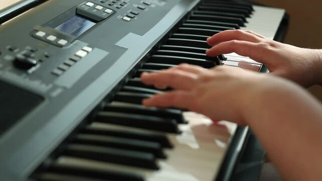 Close up of feminine hands gracefully playing piano keys, fingers dancing across ivories with practiced ease. Soft focus on moving fingers