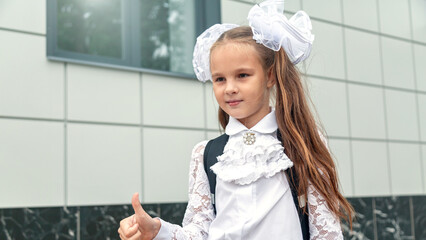 little kid girl with school satchel on first day to school. Back to school concept