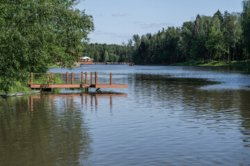 Obraz premium A Serene Lake Landscape featuring a Wooden Dock surrounded by Lush Natural Surroundings