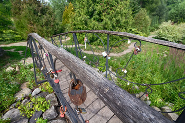 Beautiful metal forged bridge in a park consecrated by the sun. Bridge of Lovers