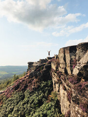 Woman standing on the top of the mountain. Curbar Edge at the Peak District National Park (August...