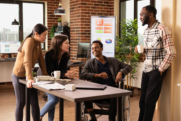 Multiethnic professionals in a startup office takes a break, enjoying a moment of laughter....