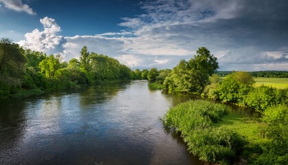 Fototapeta premium serene river flows through lush greenery under a cloudy sky