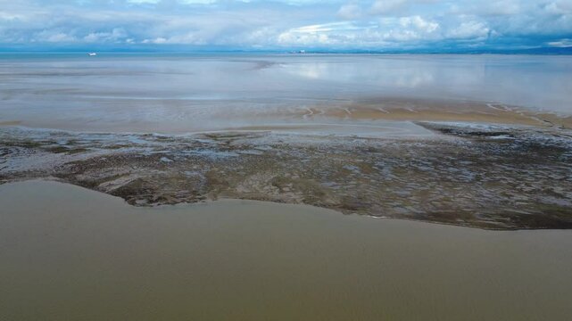 aerial drone view of the mouth of the river Wyre in Lancashire Fleetwood at low tide with the large expanse of sand looking toward the village of Heysham and the Nuclear power station in the distance