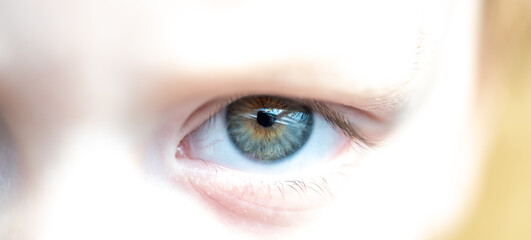 Left side of Human Kid Face with one Eye and a Blue Green Brown Colored Iris. Shot in Dayllight.