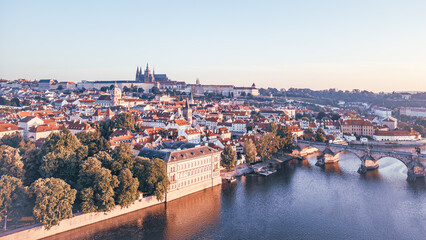 Morning light casts a warm glow on Prague's medieval cityscape, revealing the iconic Charles Bridge...