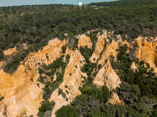 Stunning aerial photo of rugged sandstone cliffs surrounded by dense pine forest in the Lisbon...