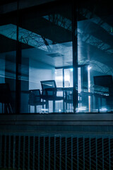 Blue lit abandoned office building through glass