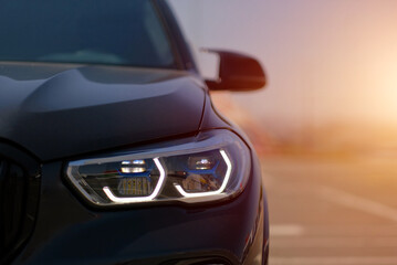 Luxury SUV Car Laser Headlight Close-Up with LED Lights at Sunset