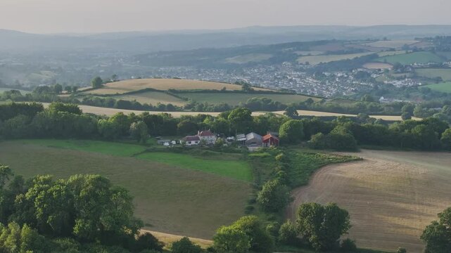 Farmer harvests hay with a tractor in the fields of Devon, Torquay, England