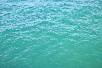 Blue Water Surface with Ripples and Sunlight Reflection
