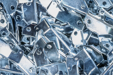 Metallic components grouped together, featuring various holes and shapes