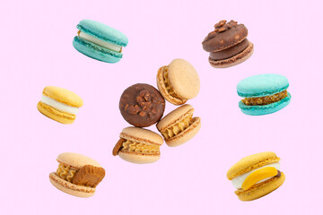 Assorted colorful macarons with fillings –  top view, pink background