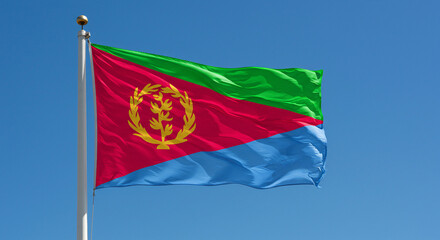 The Eritrean national flag waving steadily in the morning breeze, set against a clear sky with no other elements.