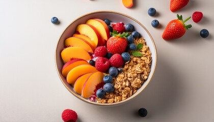 the image shows a bowl of fruit topped with granola including sliced peaches strawberries blueberries and raspberries placed on a light colored surface