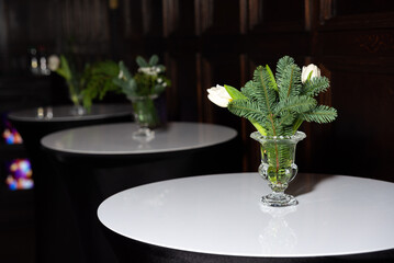 Minimalist floral vases on elegant cocktail tables.