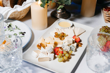 Gourmet cheese platter with fruits and nuts.