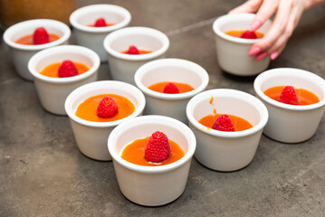 Raspberry panna cotta desserts in white ramekins.