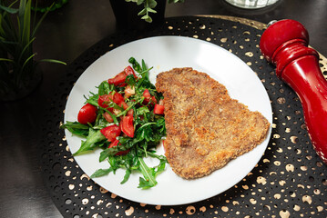 Breaded schnitzel with fresh tomato salad.