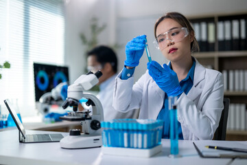 Scientist analyzing test tube with blue liquid in laboratory