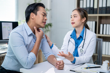 Doctor comforting patient suffering from sore throat in clinic