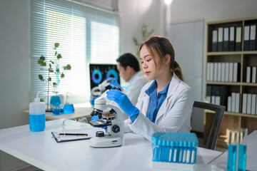 Scientists working with microscope in modern laboratory researching new medicine or vaccine