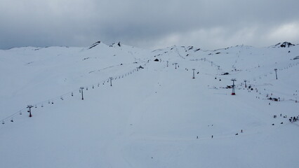 Aerial view of ski lift lines in a Chilean ski resort during winter, with snow-covered slopes and mountainous terrain creating a stunning seasonal landscape.