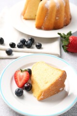 Piece of tasty bundt cake with berries on table, closeup