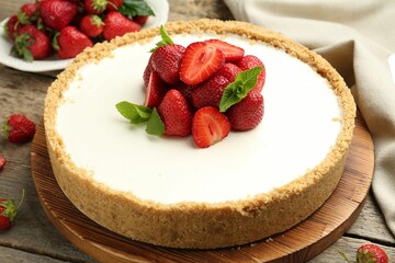 Tasty cheesecake with strawberries and mint on wooden table, closeup