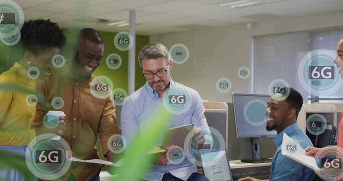 Collaborating five professionals reviewing tablet, documents at office desk, with floating 6G icons