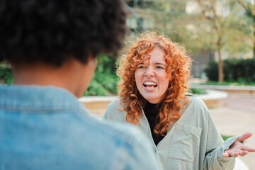 A candid moment capturing two women in a passionate dispute, highlighting their intense emotions...