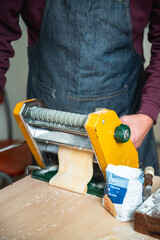 Man making homemade pasta with a noodle machine