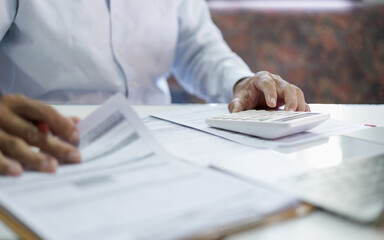 close-up shot, accountants working in office use calculators to calculate business costs, profits...