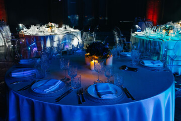 Elegant candlelit dinner tables at evening event.