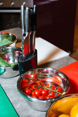 Fresh cherry tomatoes in kitchen prep station.