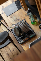 A low-angle shot capturing plates drying neatly on a dish rack inside a warm rustic kitchen, highlighting textures of wood and ceramics bathed in soft natural light.

