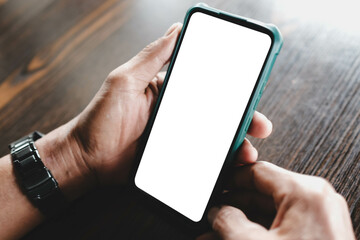Close-up of a man's hands holding a smartphone with a blank white screen. Ideal mockup template for...