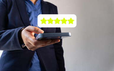A business person holding their phone with an online star review pop-up showing, highlighting the...