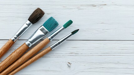 Fototapeta premium Variety of paintbrushes on a white wooden surface.