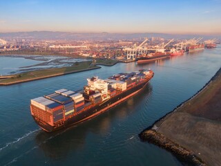 Aerial view of a container ship sailing into the Port of Oakland, California, USA. The ship is...