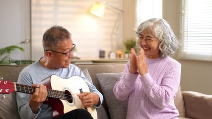 Happy retired couple bonding over live guitar music and applause in bright living space - Powered by Adobe