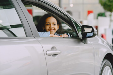 Cute african girl in modern car dealership