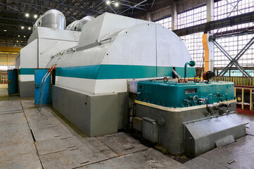 Steam turbine generators operating in an industrial facility during daytime hours with large...