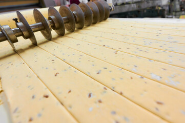 Mastering the art of dough sheeting and cutting in a bustling bakery kitchen during the morning rush