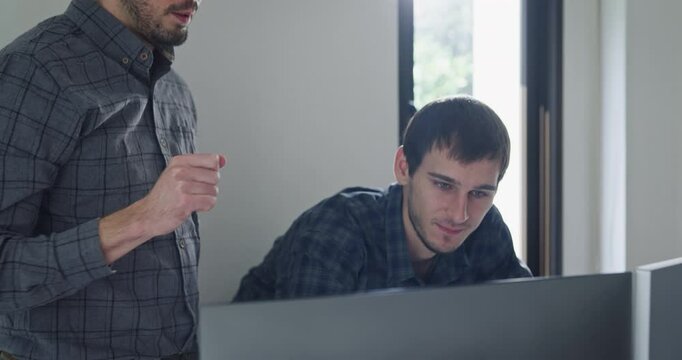 Team adult male engineer collaborate on robotic hand project using AI code solutions machine learning at tech workspace. Artificial intelligence interface, collaboration support prototype development.