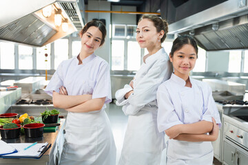 Confident Female Chefs and Students in a Professional Kitchen, Culinary Team with Mentor Posing in...