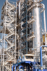 Distillation column and chemical processing unit in an industrial plant during daylight showcasing efficiency and advanced technology