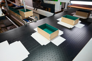 Innovative automation at a decorative box factory showcases advanced robotics handling cardboard boxes on the conveyor belt