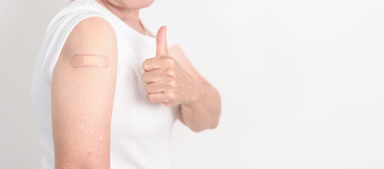 Elderly Woman with bandage after received vaccine. Vaccination and Immunization for Influenza, Herpes Zoster, Tetanus, Covid 19 booster, Dengue, Encephalitis, Rabies, Pneumococcal, IPD, RSV Vaccines