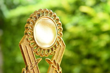 beautiful golden trophy of football contest on green tree background